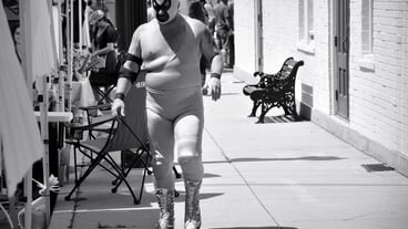 Man wearing costume and face paint while walking on footpath