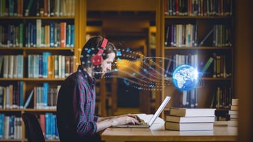 Composition of digital globe over male student using laptop in library