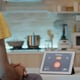 Man looking at tablet with intelligent software placed on kitchen table controlling light with high ...