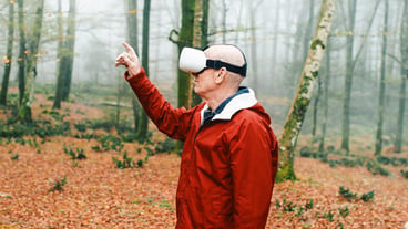 Old man experiences virtual reality in nature in the forest