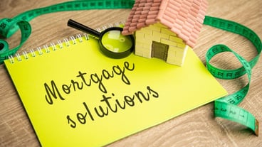 Mortgage Solutions concept Assistance in purchasing a new home refinancing existing mortgages and reduce their monthly payments Real estate and loan rates Notes and miniature house