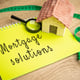 Mortgage Solutions concept Assistance in purchasing a new home refinancing existing mortgages and reduce their monthly payments Real estate and loan rates Notes and miniature house