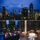 A glamorous rooftop party in a penthouse suite overlooking a city skyline with live music and gourme