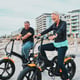 Senior couple electric bike and smile by the beach for fun bonding cycling or travel together in the city Happy elderly man and woman enjoying cruise on electrical bicycle for trip in Cape Town