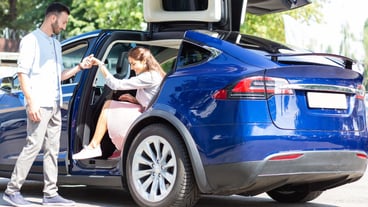 Helpful loving husband. Helpful loving husband giving hand to his appealing stylish wife leaving car