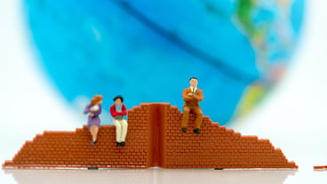 Miniature people: stand-up entrepreneur with wall and world. Problem solving concepts.