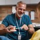 Smiling Dentist Showing Dental Model to Patient