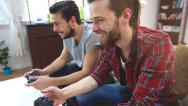 Affectionate men playing playstation in the living room