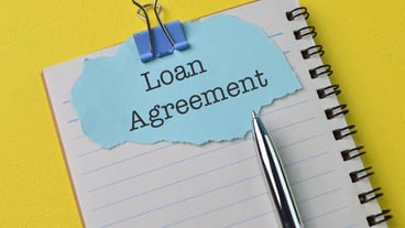 Pen notebook and torn paper with text LOAN AGREEMENT