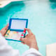 Hand holding Water Test Kit on blurred pool background Hand holding a pool ph and chlorine tester Person holding complete water test kit with blurred pool background