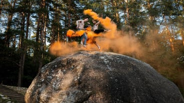 Low angle view of friends jumping on rock