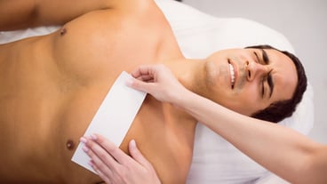 Man getting his chest waxed with wax strip