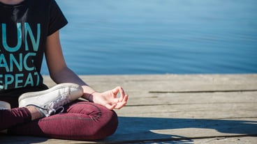 Cropped teenager meditates on the pier