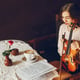 beautiful elegant girl sitting in a cafe with violin and drinking coffee