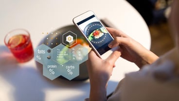 hands with phone and food nutritional value chart