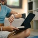 Young woman checking her smartwatch and following an online fitness session at home