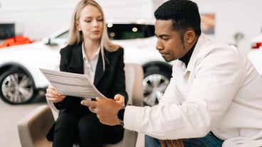 Medium shot of female manager consulting doubtful black buyer giving purchase agreement for review