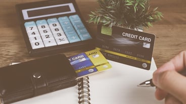 Male hand holding credit card to calculate the cost and shopping online
