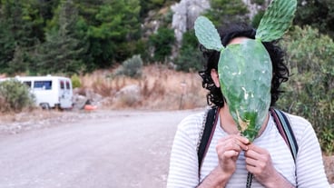 Portrait of a man with a cactus plant on the side of the road