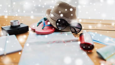 vacation, tourism and winter holidays  concept - travel map, hat, camera with flip-flops and sunglasses on table over snow