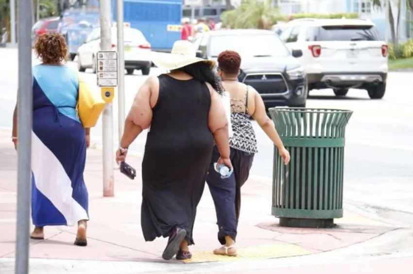 mulher-obesa-com-vestido-preto-longo-e-chapeu-caminha-pela-calcada-_1_92834