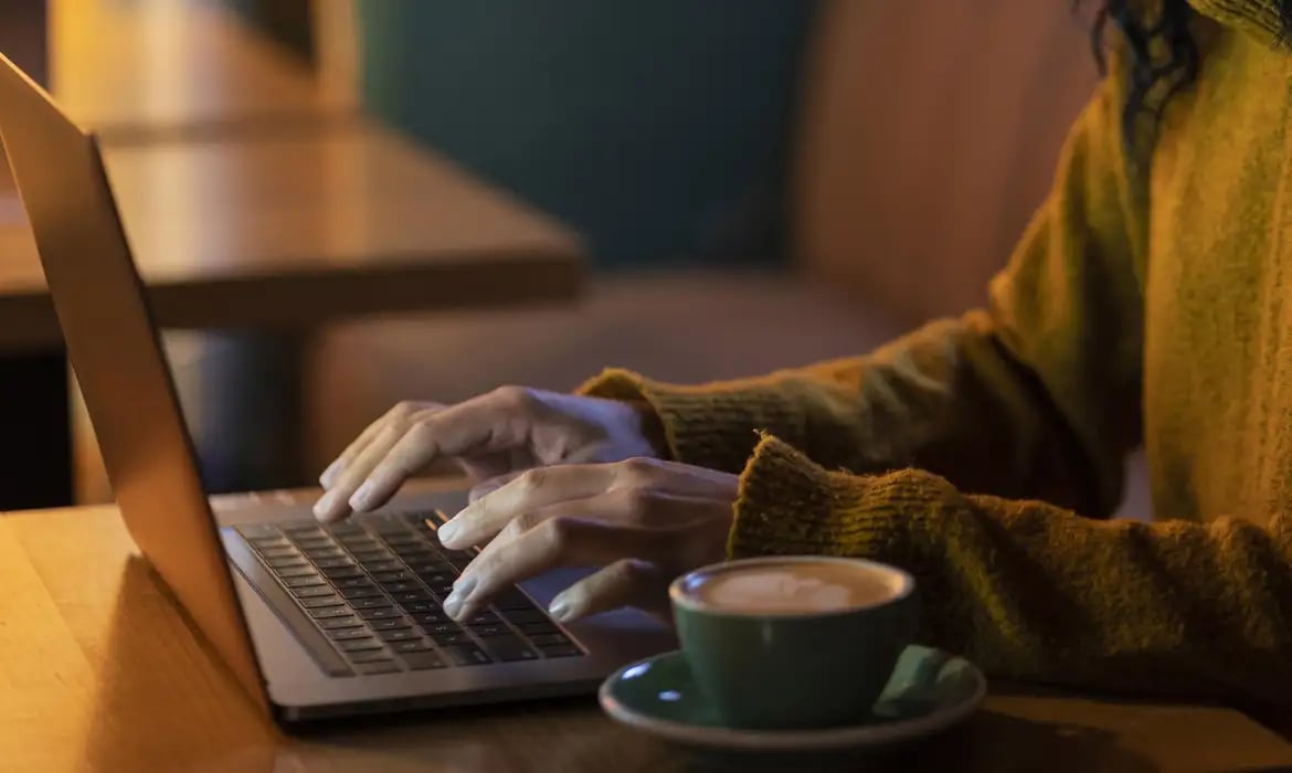 mulher-de-lado-trabalhando-em-seu-laptop-em-uma-cafeteria