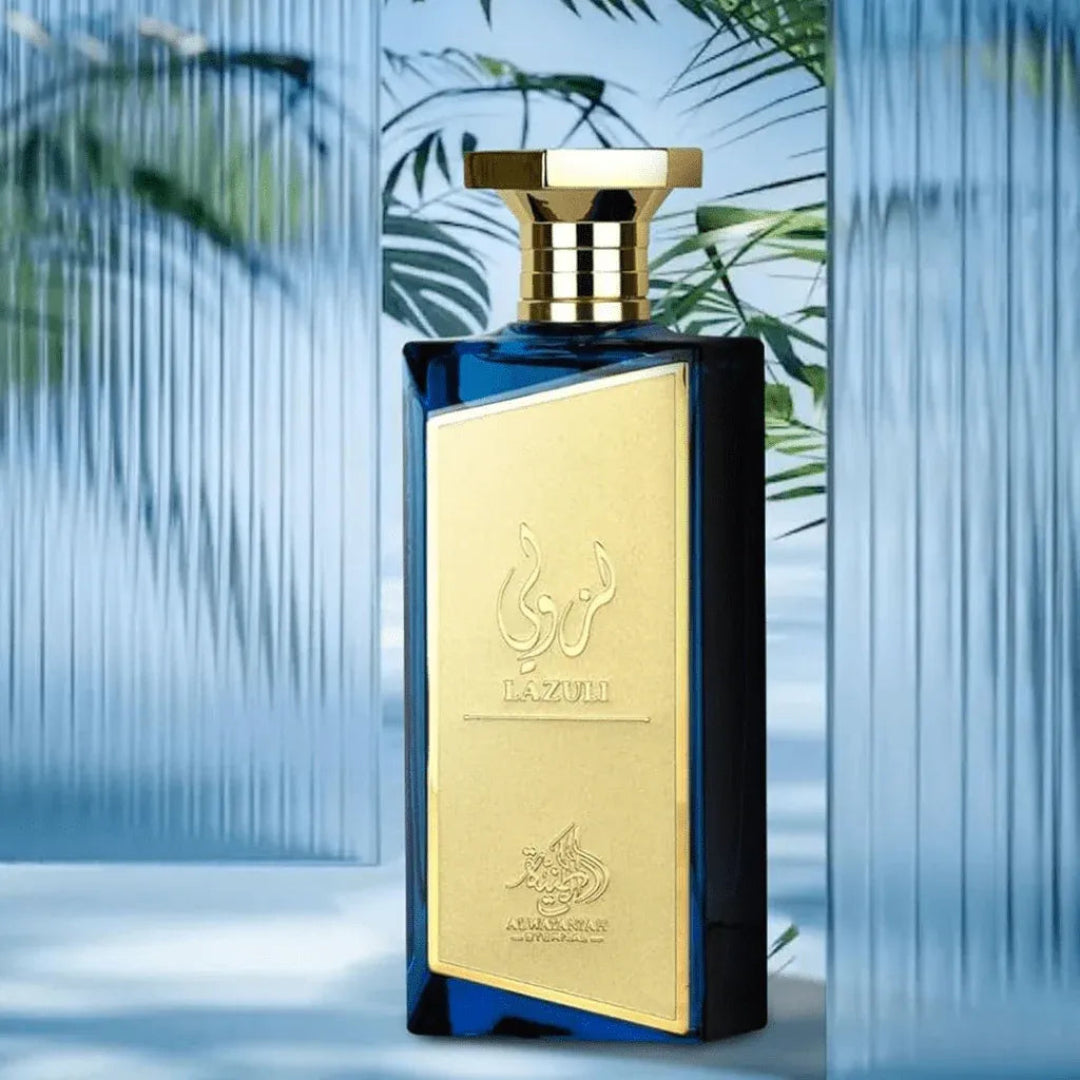 Perfume bottle with gold and blue design against a blurred natural background