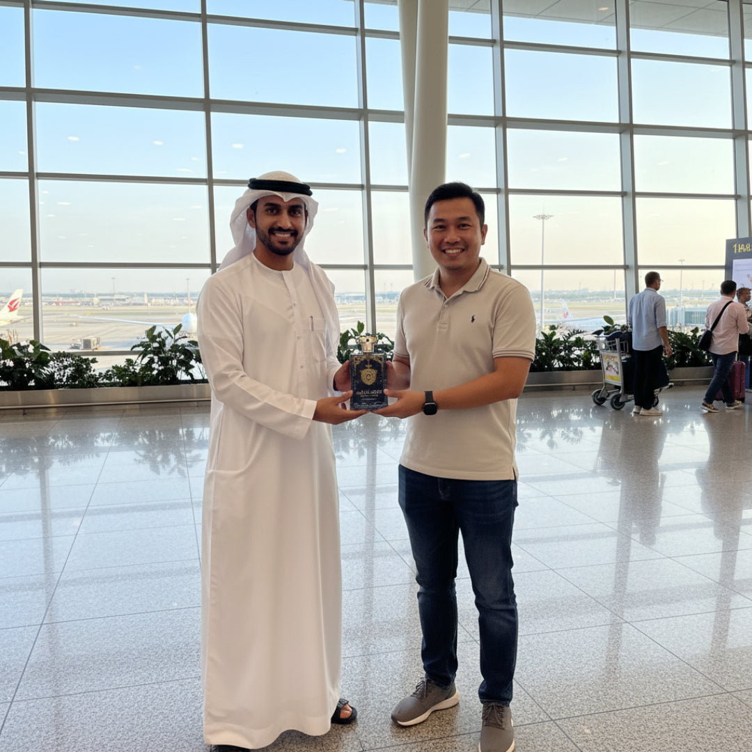 Two men standing in an airport terminal, one holding a trophy.