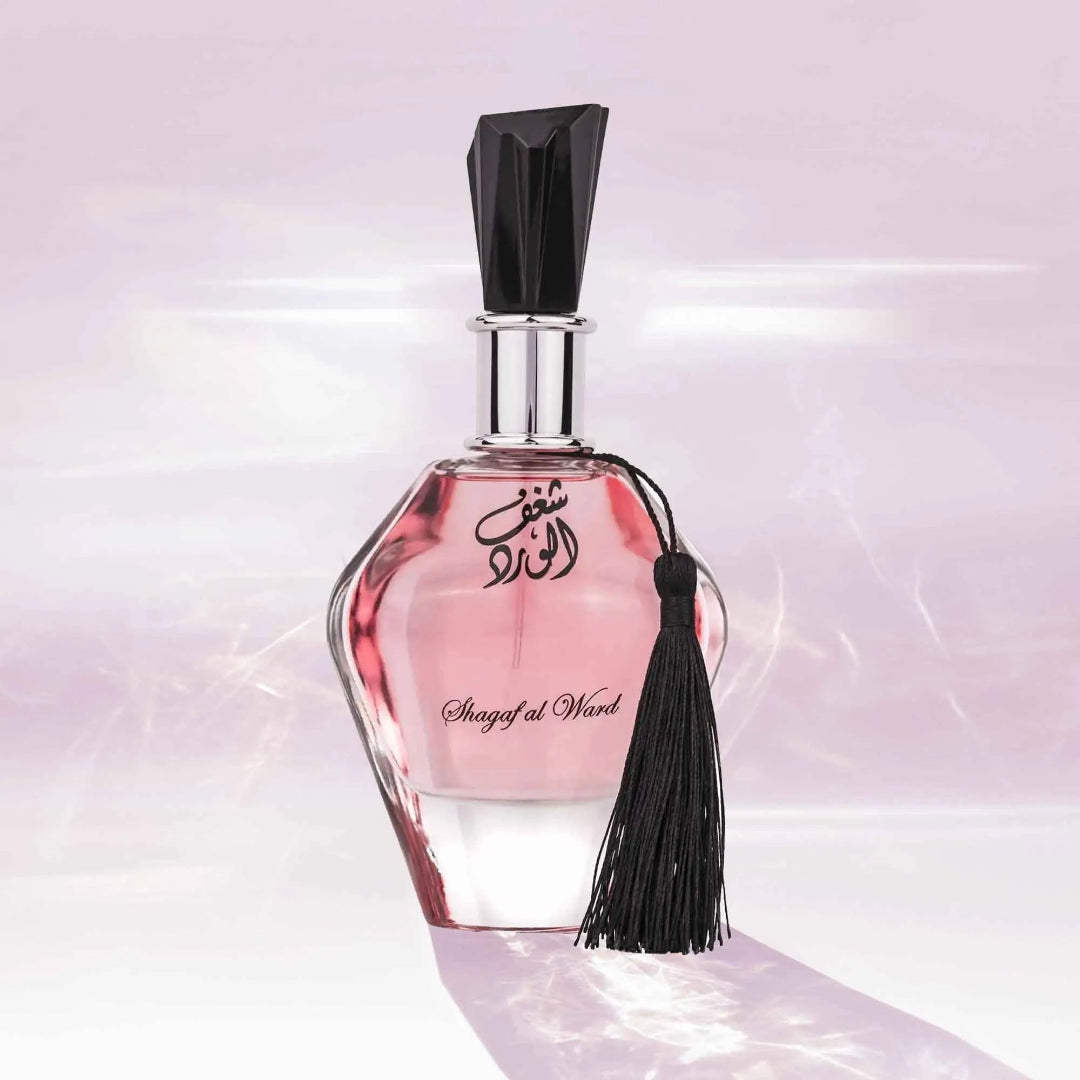Perfume bottle with pink liquid and black cap on a light pink background