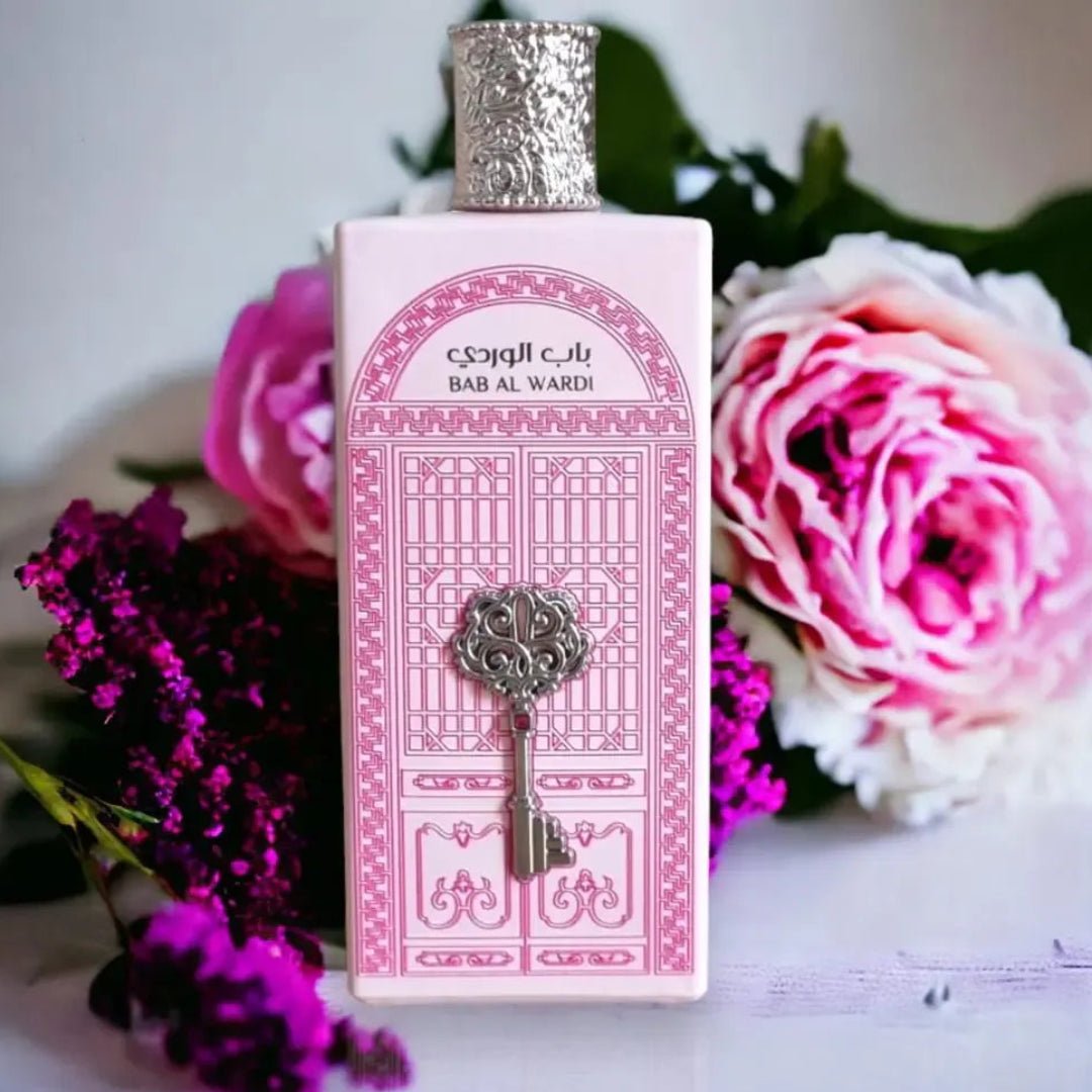 Bottle of Baa Al Wardi perfume with decorative box and flowers in the background