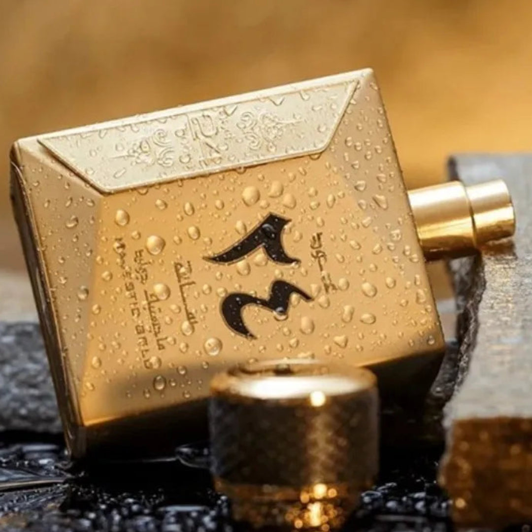 Gold perfume bottle with water droplets on a textured surface