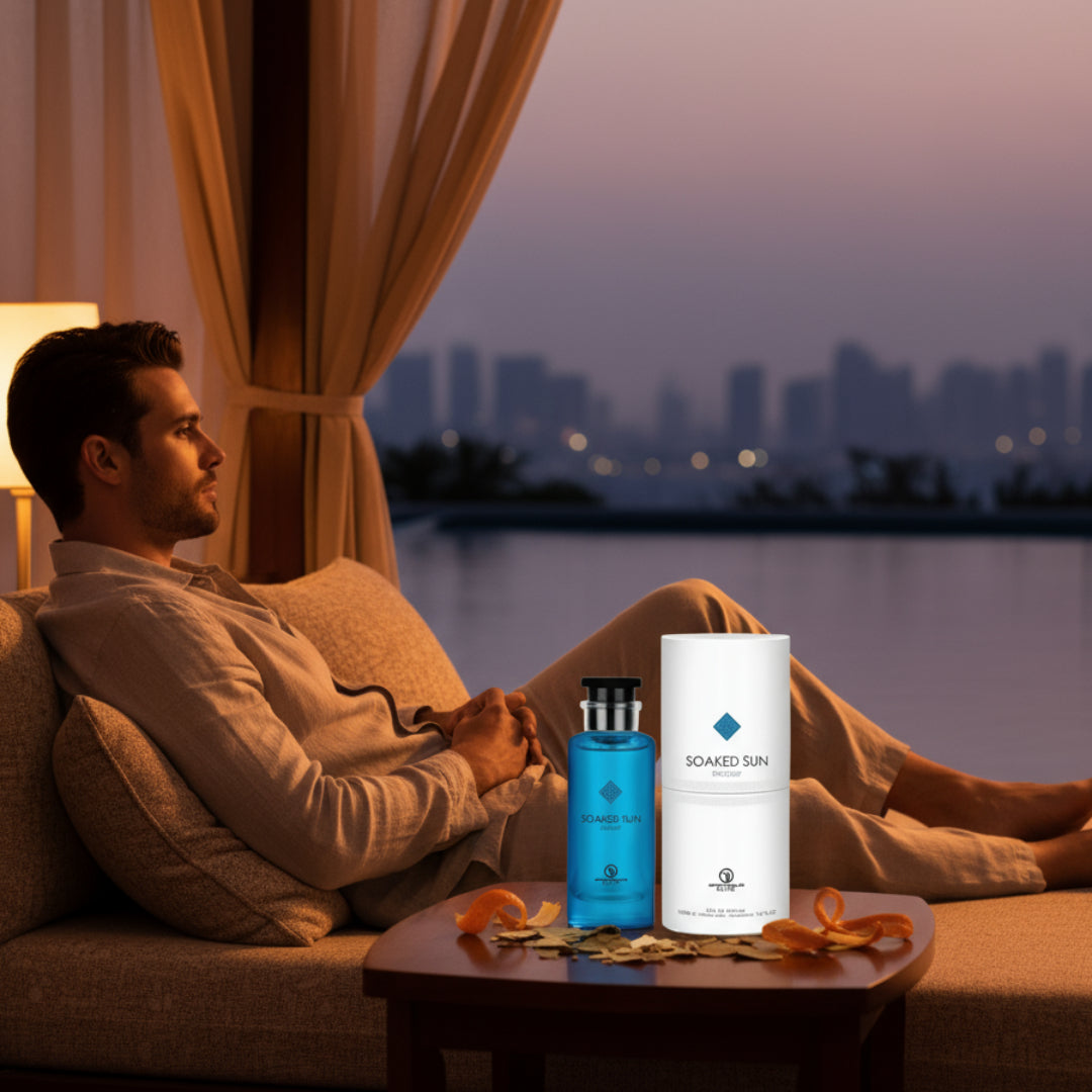 Men’s perfume bottle and box at poolside cabana Malaysia at dusk with orange peel props &ndash; summer evening woody fresh fragrance