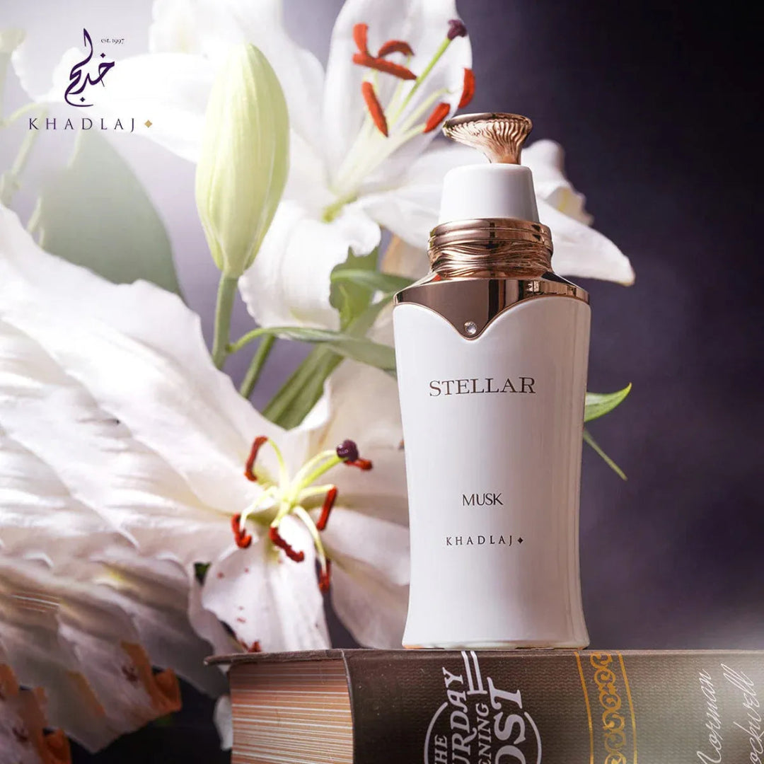 Stellar Musk perfume bottle by Khadlaj with white lilies in the background