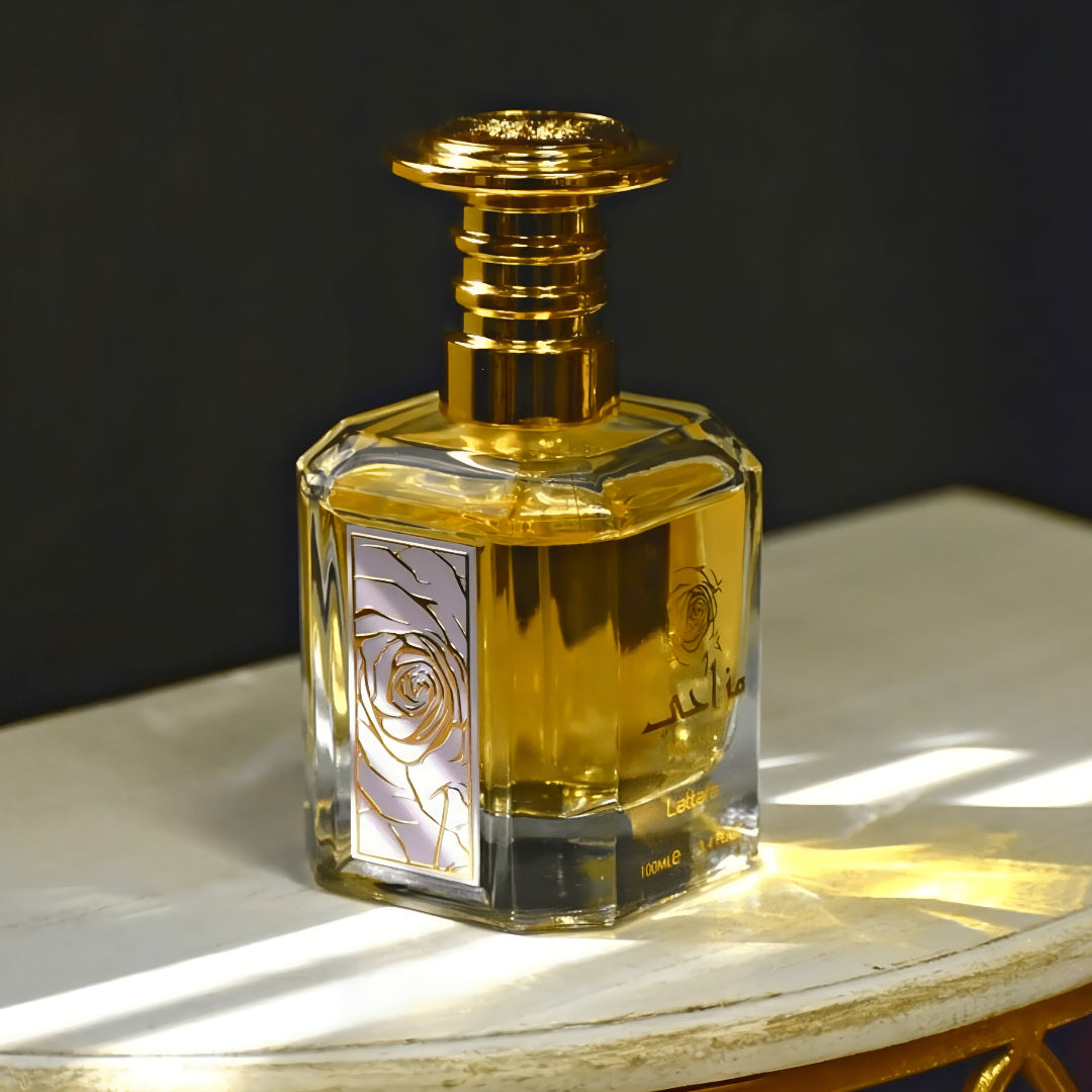 Gold and clear perfume bottle with decorative label on a wooden surface