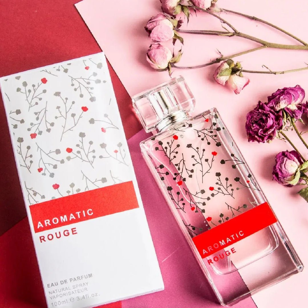 Perfume bottle and packaging with floral design on a pink background