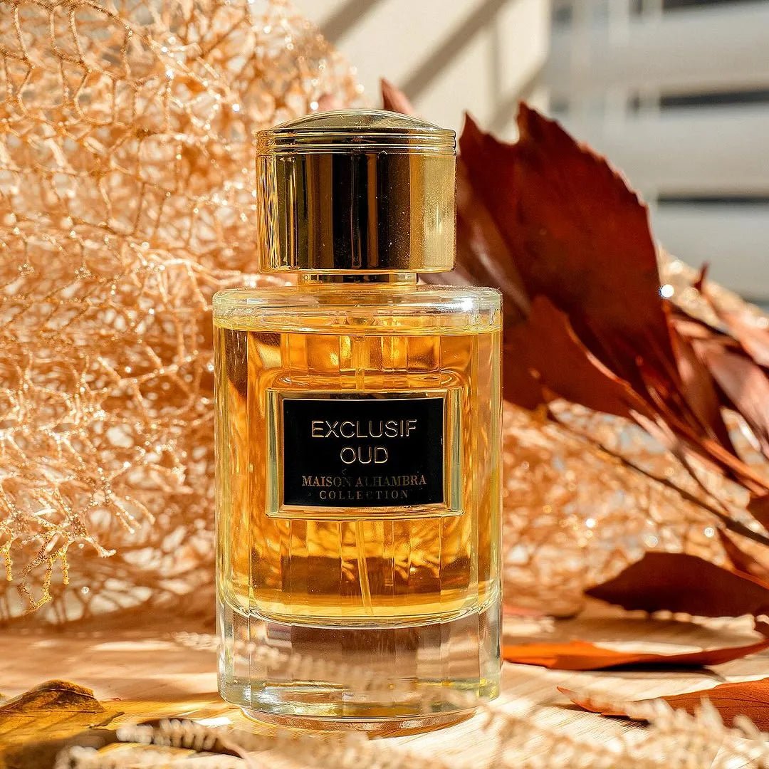 Perfume bottle labeled 'Exclusif Oud' with a gold cap on a decorative background.