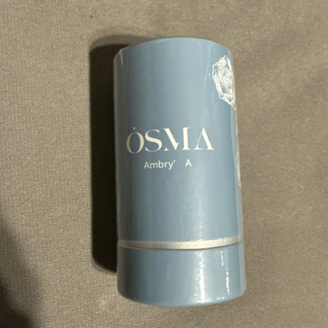 Blue cylindrical container with 'OSMA' branding on a beige background