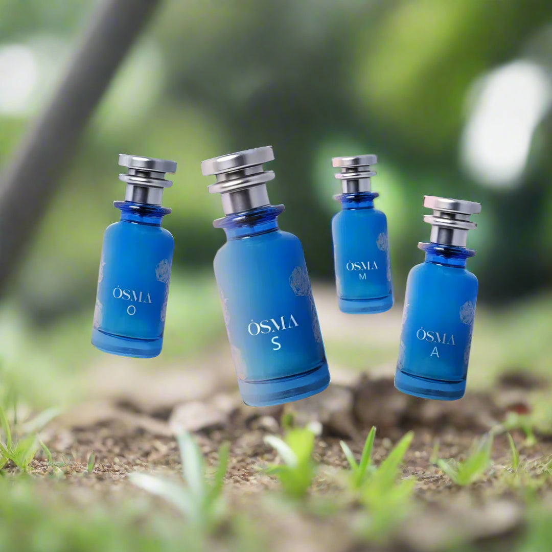 Four blue perfume bottles labeled 'OSMA' against a scenic background with water and sky.