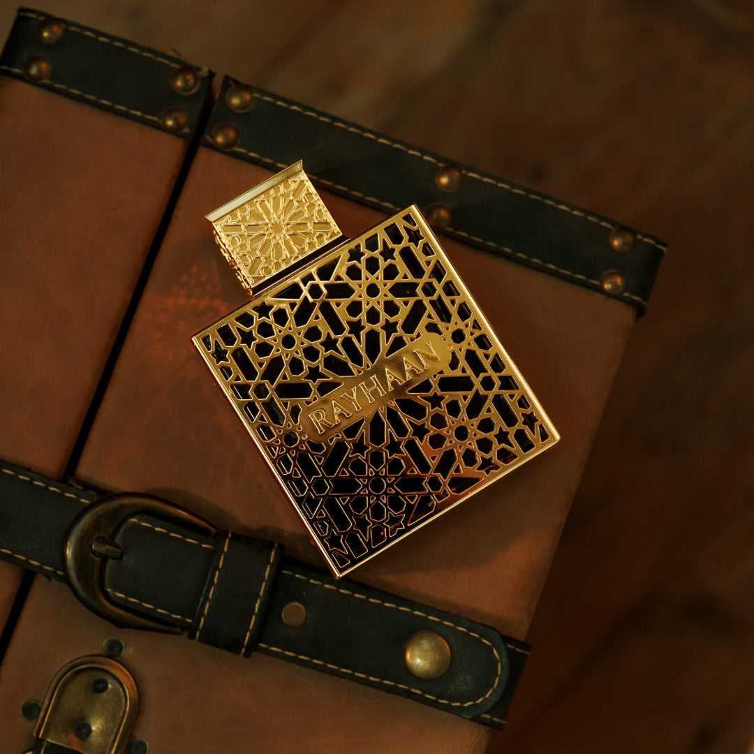 rayhaan elixir perfume bottle with intricate design on a brown leather surface