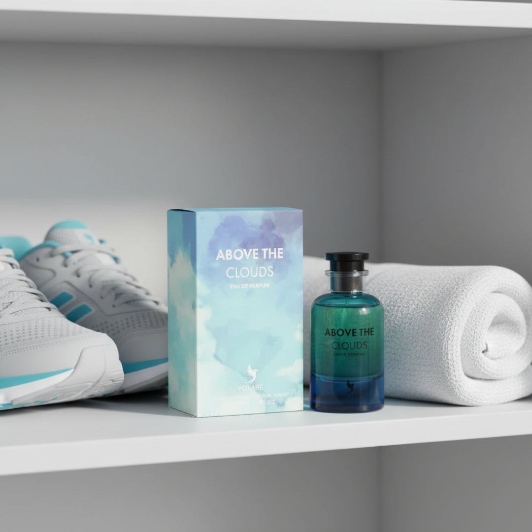 Perfume bottle and packaging labeled 'Above the Clouds' on a shelf with white sneakers and a towel.