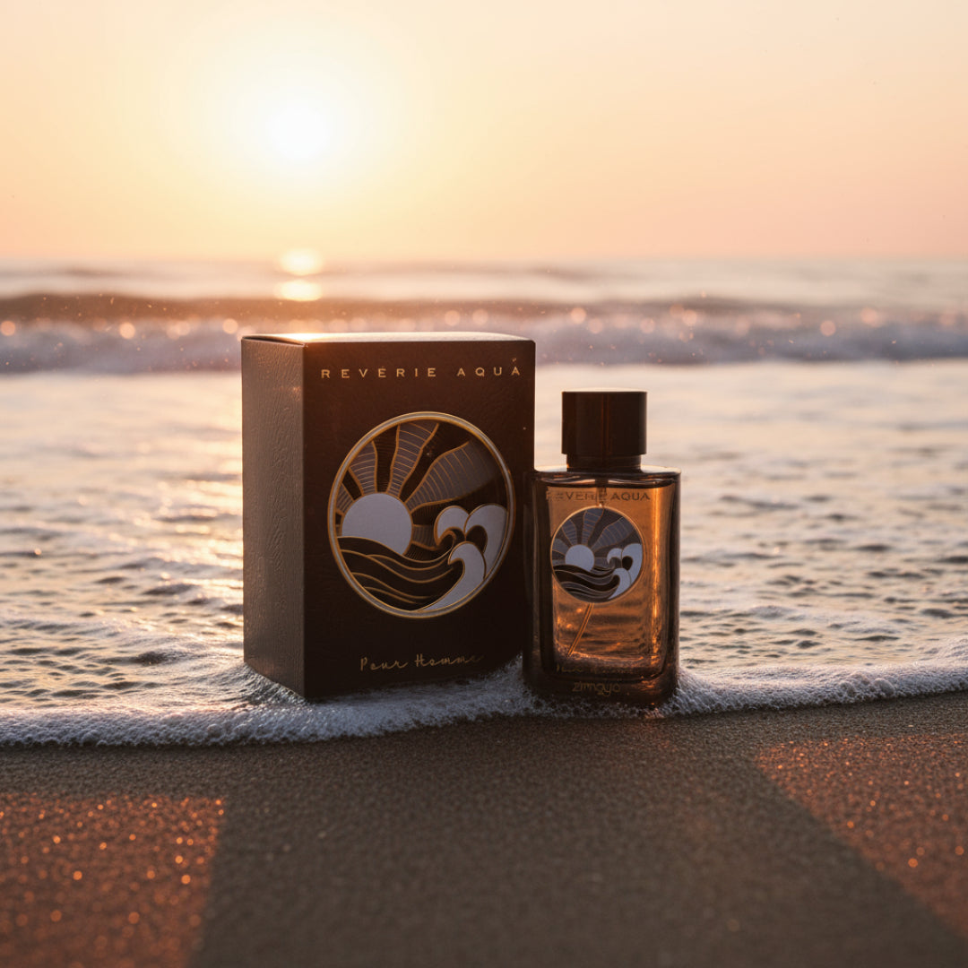 Reverie Aqua by Zimaya perfume bottle on beach sand with sunset and waves fresh scent Malaysia