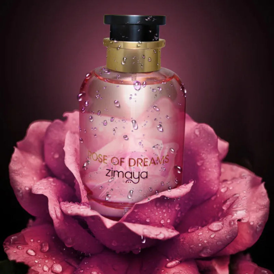 Perfume bottle labeled 'Rose of Dreams zimaya' on a pink rose with water droplets.