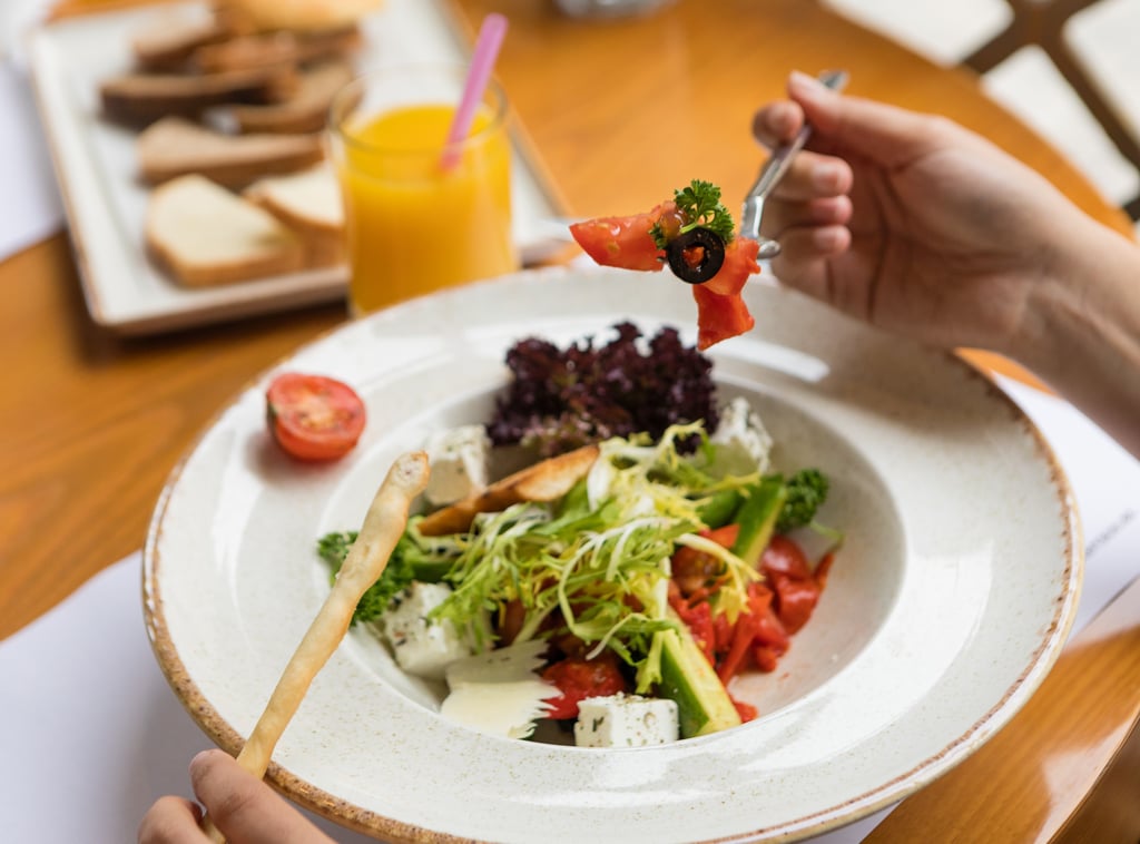 Woman eating beautiful vegetarian salad close up