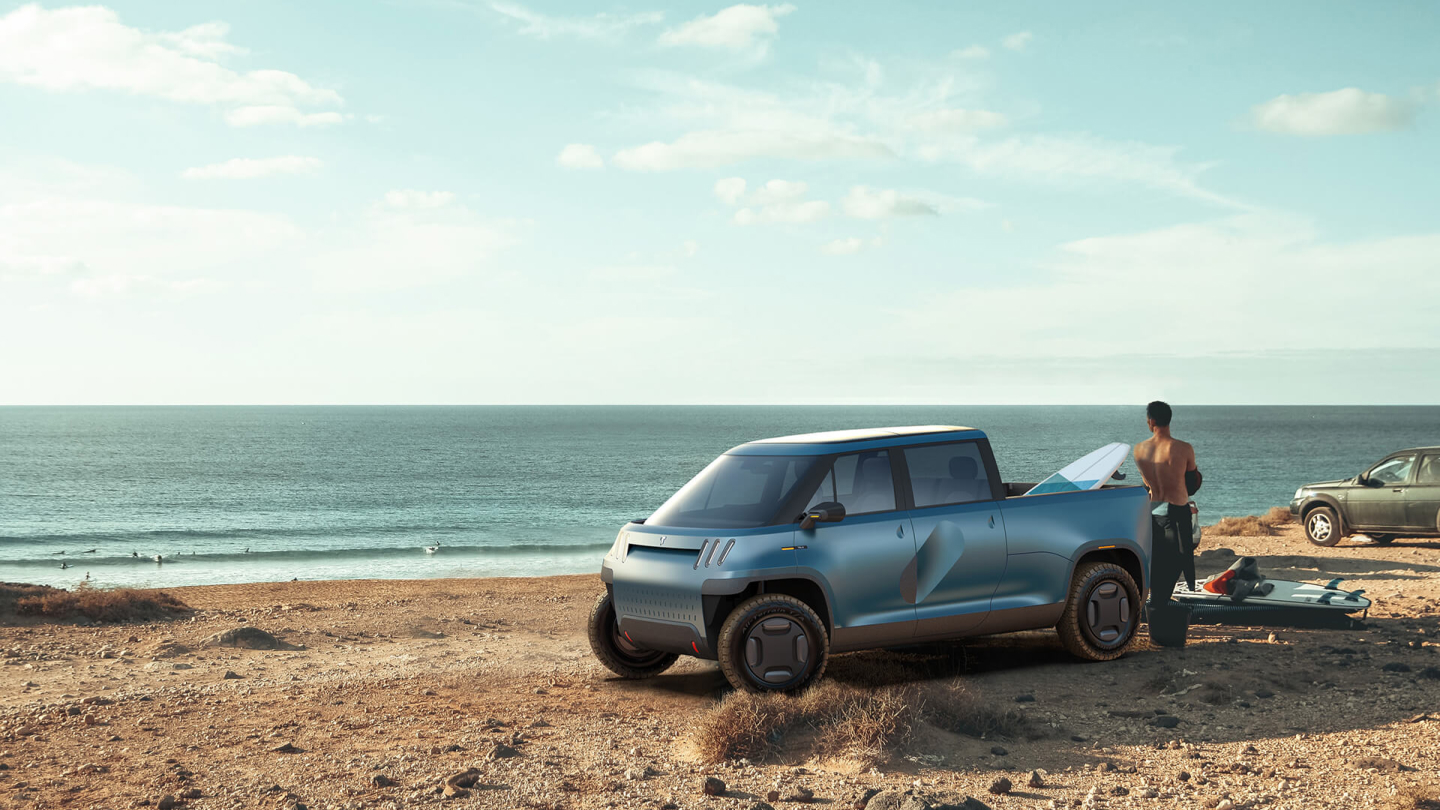 Man near pickup truck on sandy beach