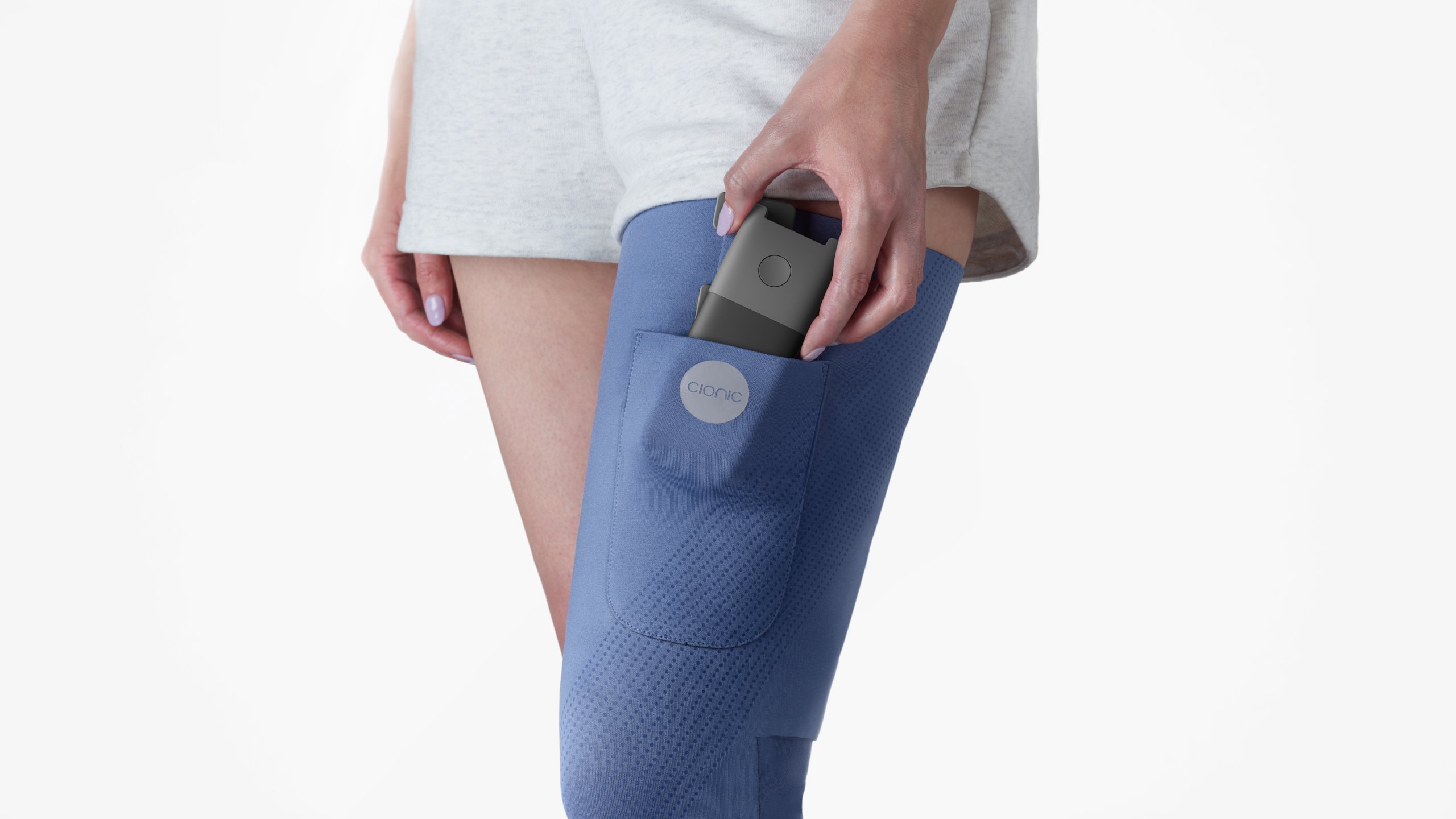 Person wearing blue knee brace and holding a smartphone