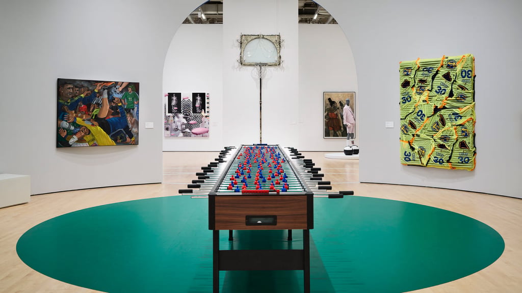 Green floor and white walls surround art gallery with pool table