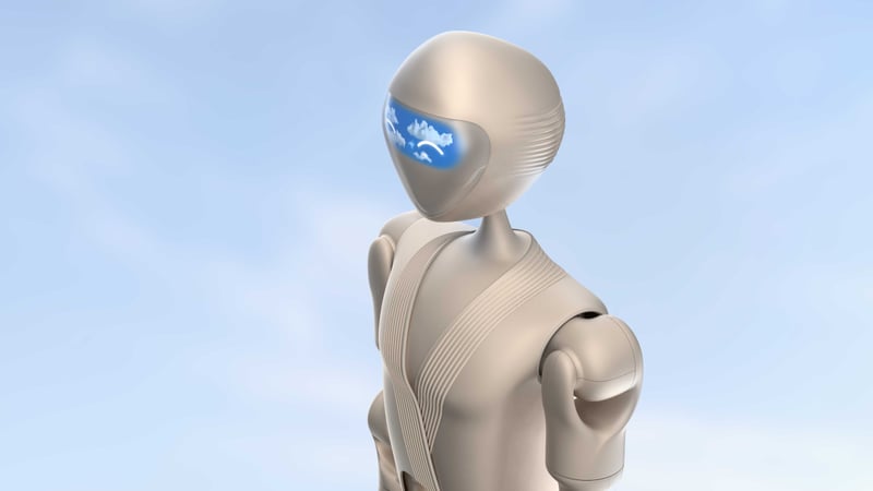 Kindred humanoid robot concept with beige body and translucent visor face shown against a soft sky backdrop.