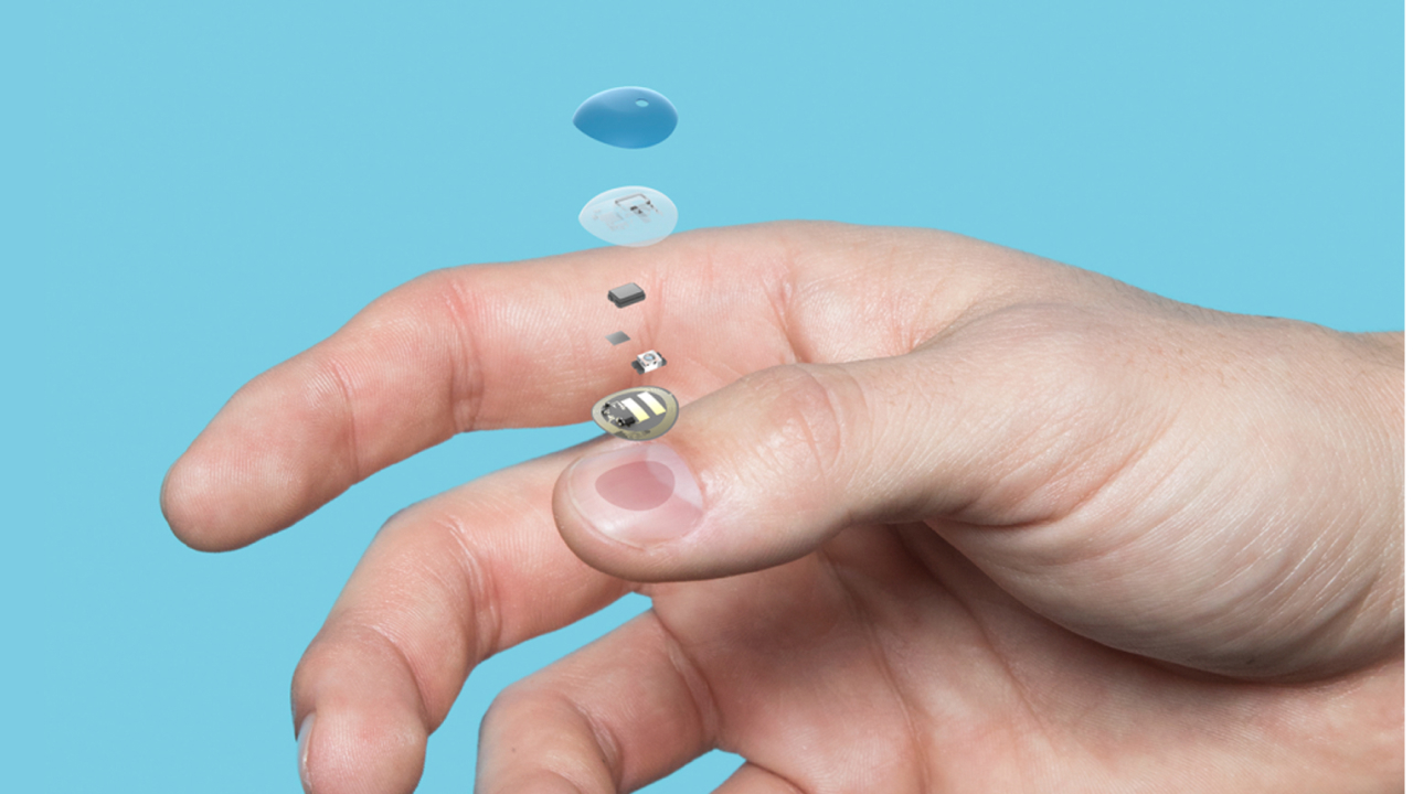 Hand holding blue pill with colorful capsules