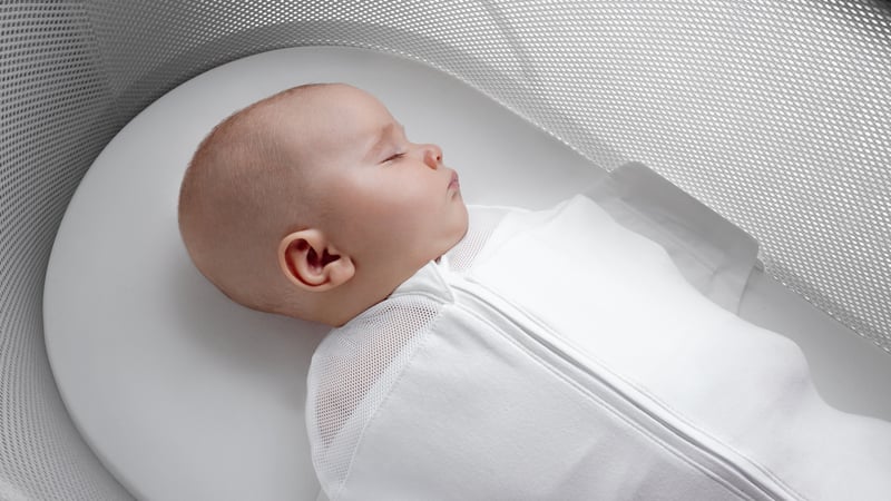 Newborn sleeping in Happiest Baby SNOO bassinet