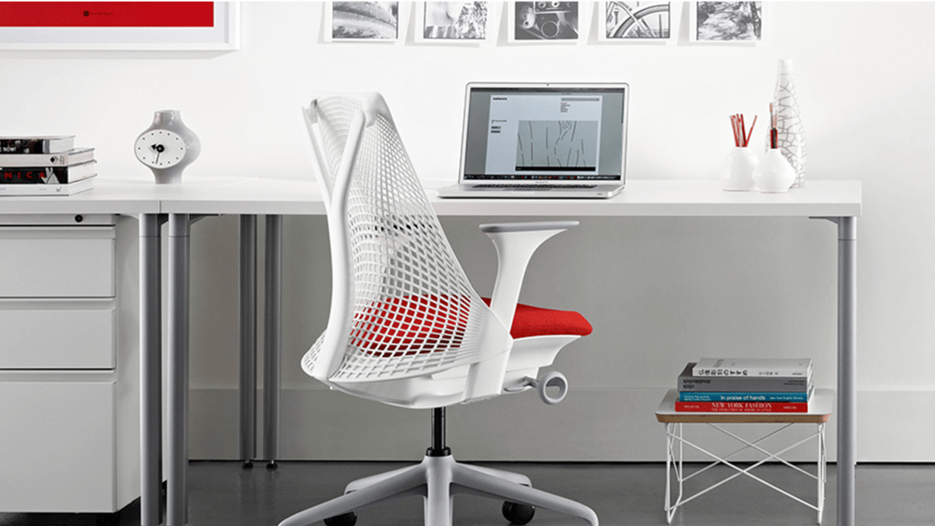 Modern home office with desk, chair, laptop, and framed pictures